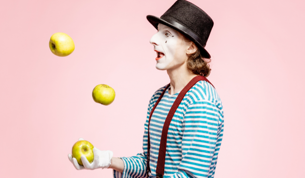 cyrkowiec żongluje jabłkami