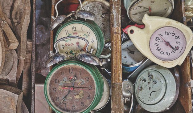 kłębowisko starych, kolorowych zegarów; jeden w kształcie kurki