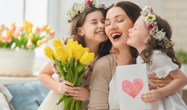 mama i dzieci z kwiatami i laurką z czerwonym sercem