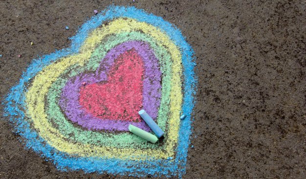 Zdjęcie wielokolorowego serca narysowanego na betonie kredą