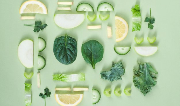 Kompozycja z połówek plastrów cytryny, limonki, ogórków, oliwek, zielonych listków świeżych warzyw symbolizująca zdrowe odżywianie.