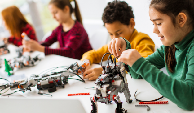 dzieci na zajęciach z robotyki, budują roboty z klocków