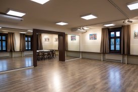 Zdjęcie przedstawiające jasne wnętrze zabytkowego Klubu Krzesławice. Duża, pusta sala, jedna ściana pokryta lustrami.