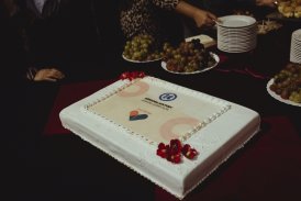 Wnętrze Teatru. Na stole z przekąskami leży biały lekko przyozdobiony tort z okazji Jubileuszu 30-lecia Ośrodka Kultury Kraków-Nowa Huta.
