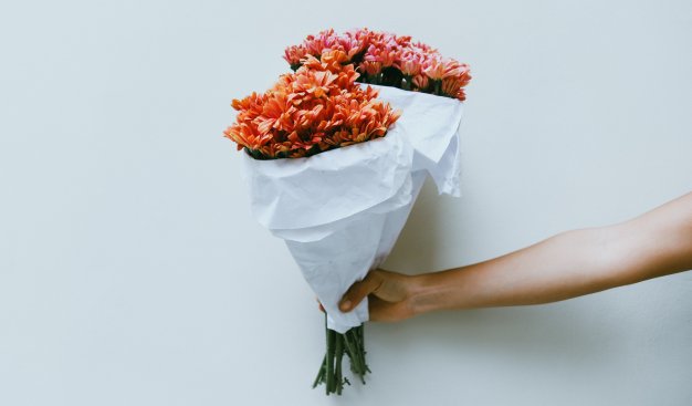 Zdjęcie ręki trzymającej dwa bukiety kwiatów
