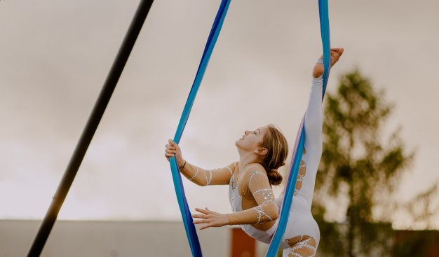 Zdjęcie dziewczynki podwieszonej na linach cyrkowych