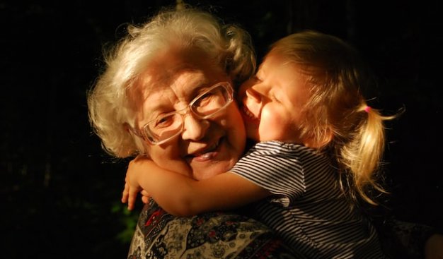 Zdjęcia starszej kobiety do której przytula się mała dziewczynka