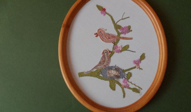 Na zdjęciu widać pracę przedstawiającą  dwa barwne ptaki na gałęzi.