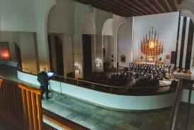Wnętrze kościoła, na balkonie aktor czytający tekst, w tle widać ołtarz i chór