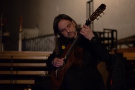 Zdjęcie gitarzysty Marcina Majerczyka grającego na gitarze.