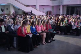 Zdjęcie przedstawiające publiczność koncertu siedzącą w ławkach kościelnych.