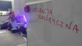 Zdjęcie przedstawiające białą tablicę na której znajduje się napis Integracja sensoryczna