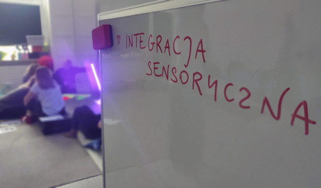 Zdjęcie białej tablicy na której widnieje napis "integracja sensoryczna"
