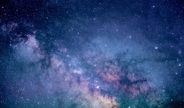 Wycinek rozgwieżdżonego nieba, z fragmentem Drogi Mlecznej podświetlonej blaskiem odległych gwiazd.