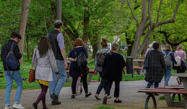 zdjęcie grupki kilkunastu osób spacerujących przez Park Ratuszowy